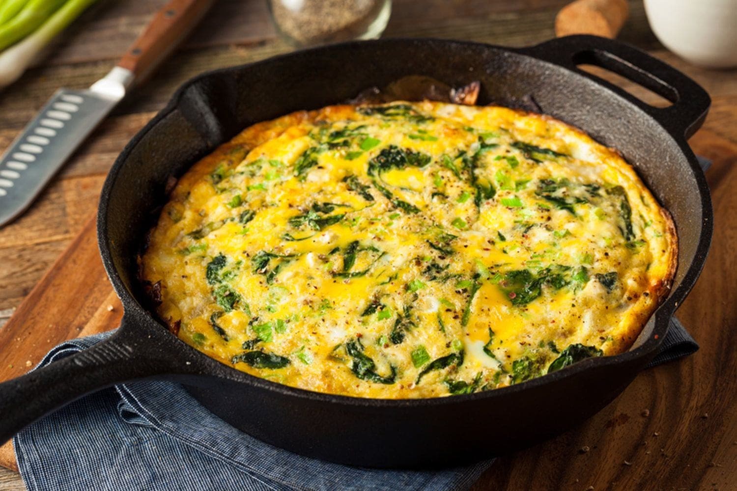 A folded omelette filled with spinach and feta, served on a white plate.
